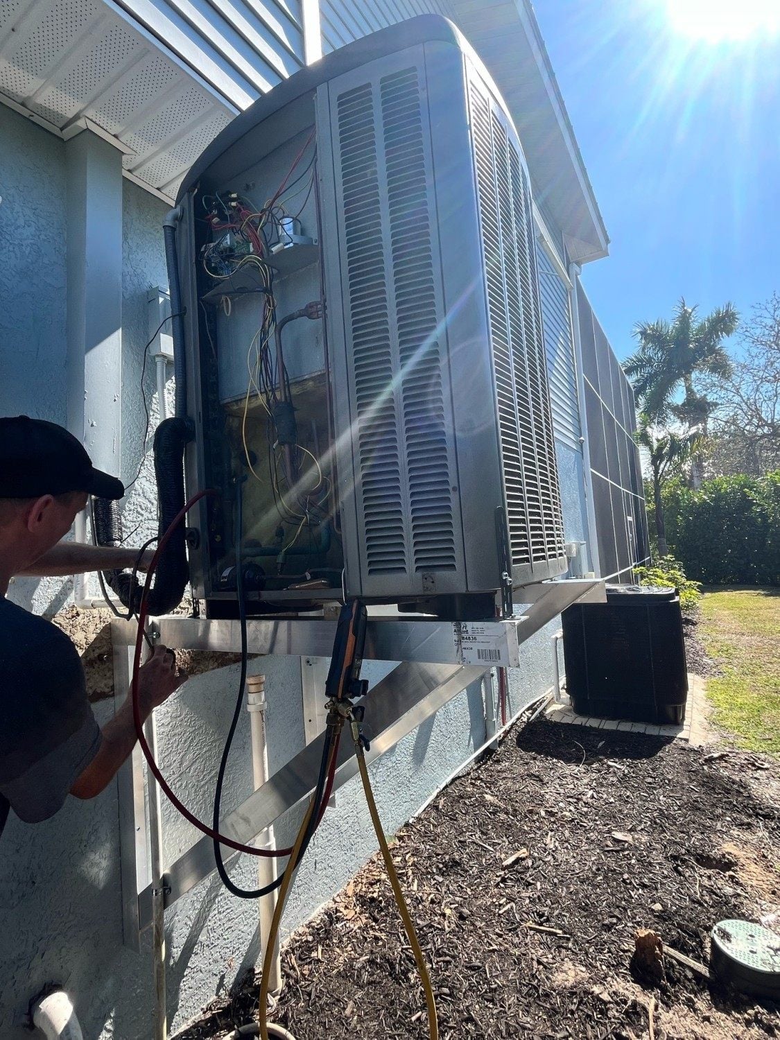 Always Be Cooling technician repairing an AC condenser in Southwest Florida